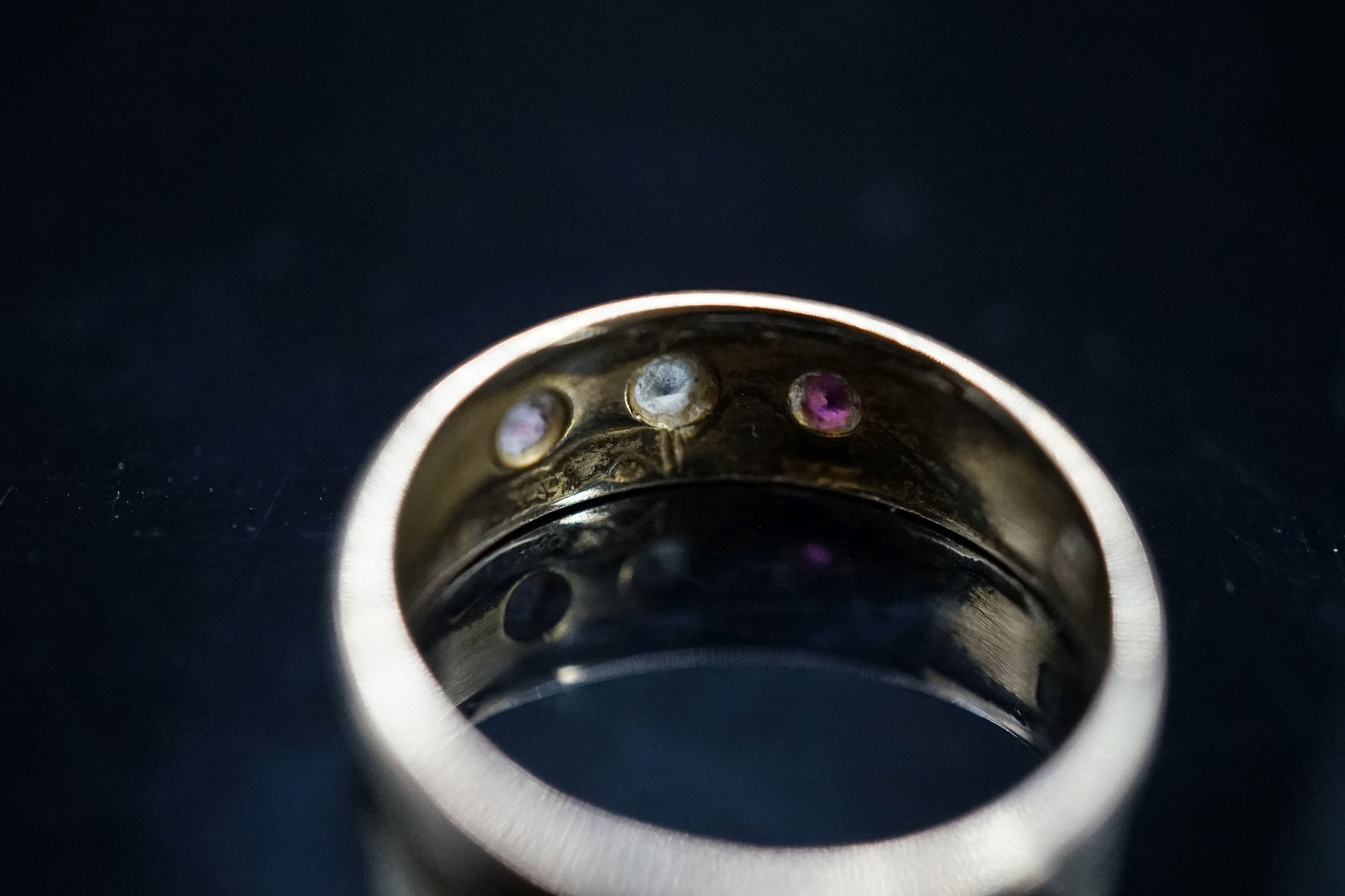 An early 20th century yellow metal and gypsy set ruby and diamond set three stone ring, size O, gross 3.9 grams.